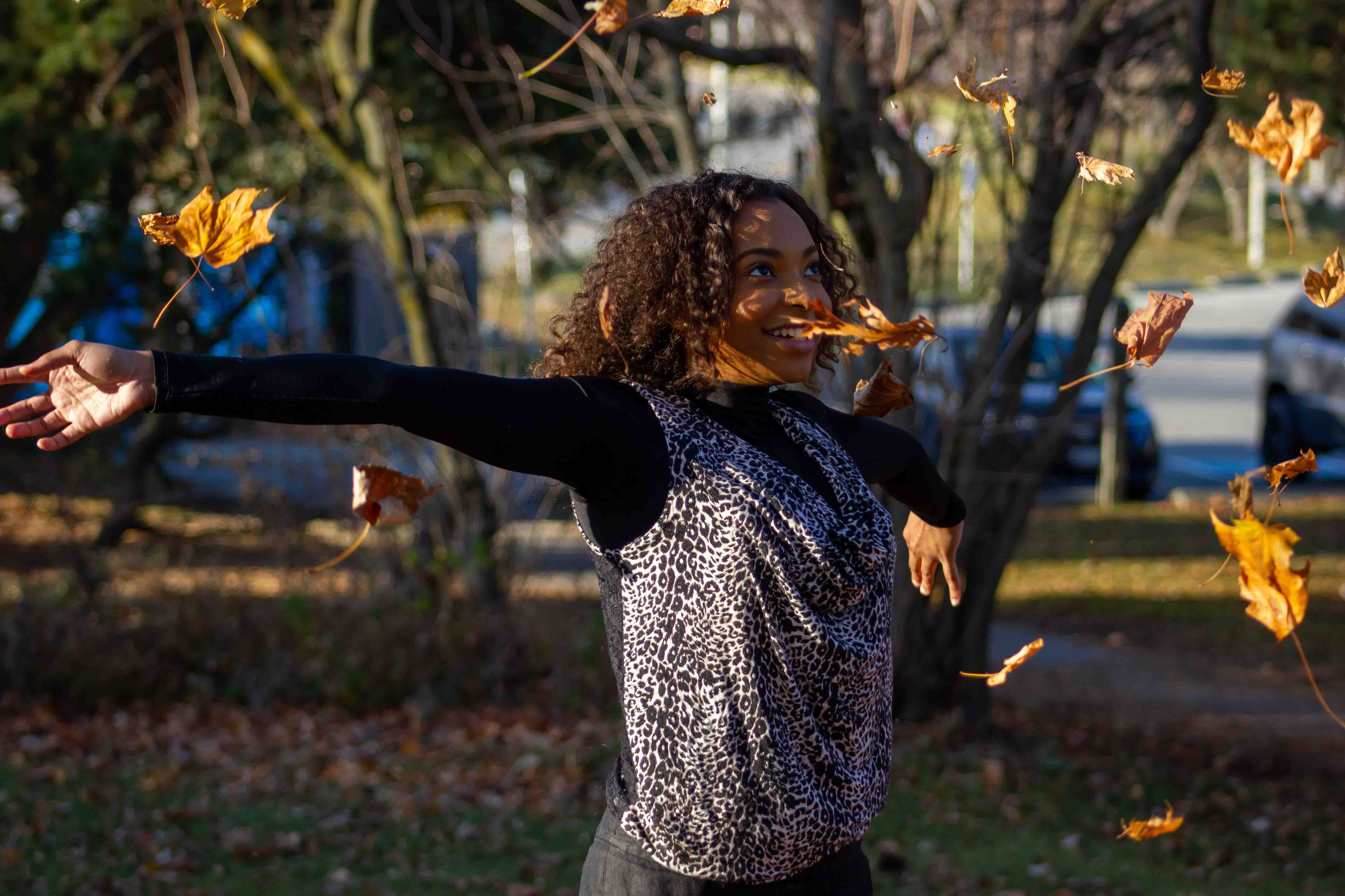 Leaves frozen in time in the fall with girl's arm stretched out 